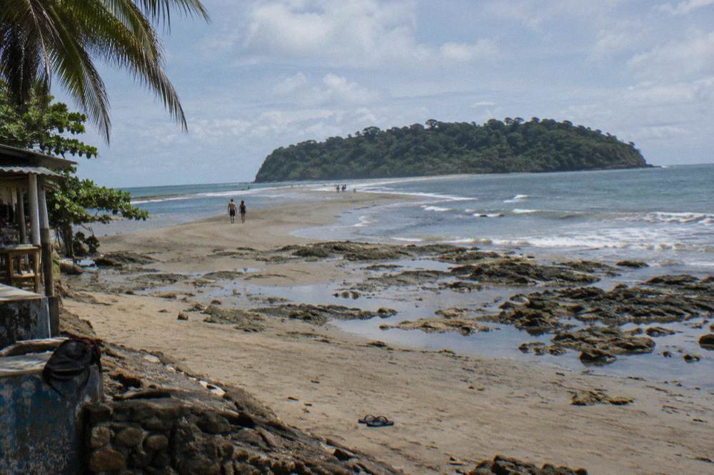 A sandy tombolo stretching into blue ocean at low tide