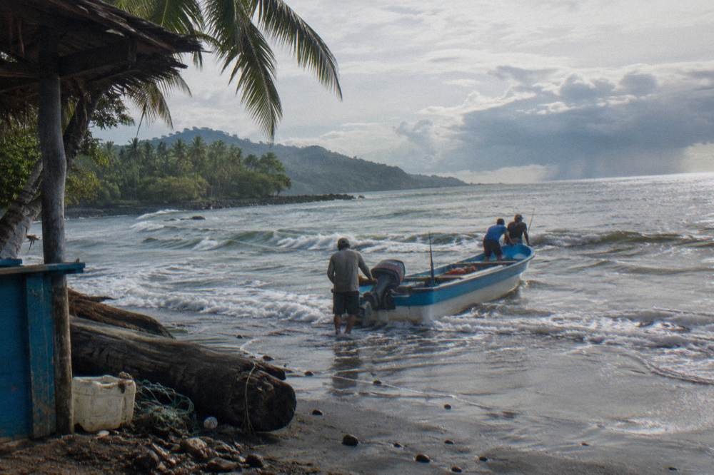 Small tour boat heading out over gentle morning waves toward open water