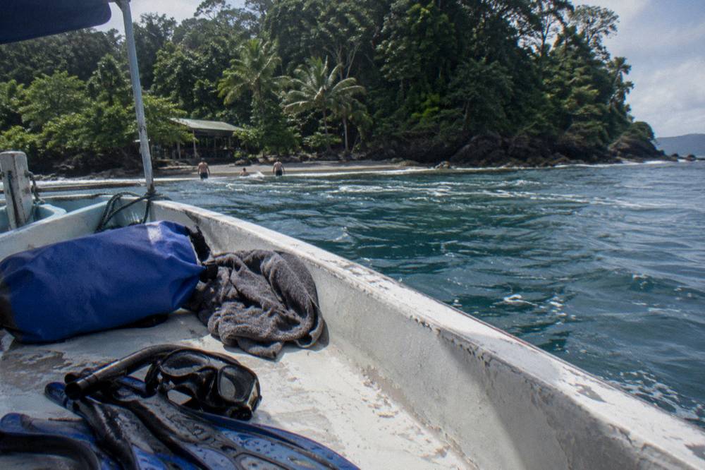 Dry bag and towel resting on a boat bench with snorkel gear beside it