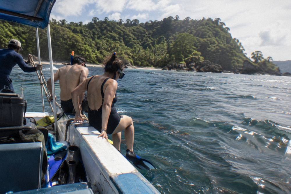 Snorkel boat moored near a reef with passengers preparing to enter the water