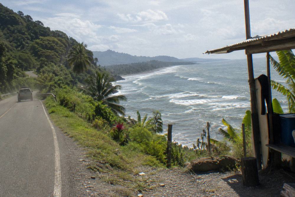 A coastal highway curving along green hills above the ocean