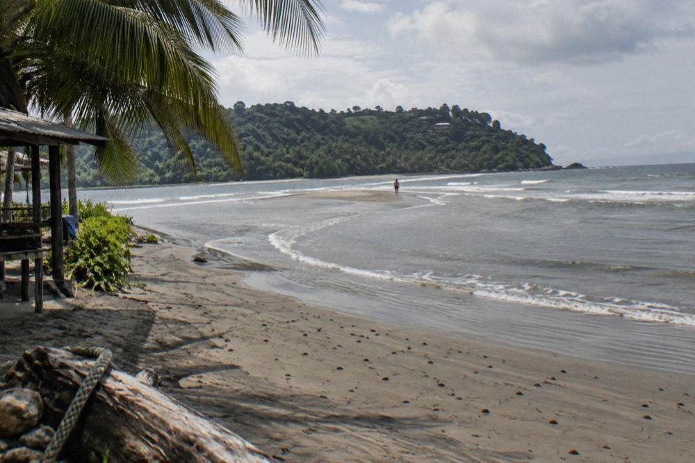 Curving whale tail sandbar extending into a calm tropical bay