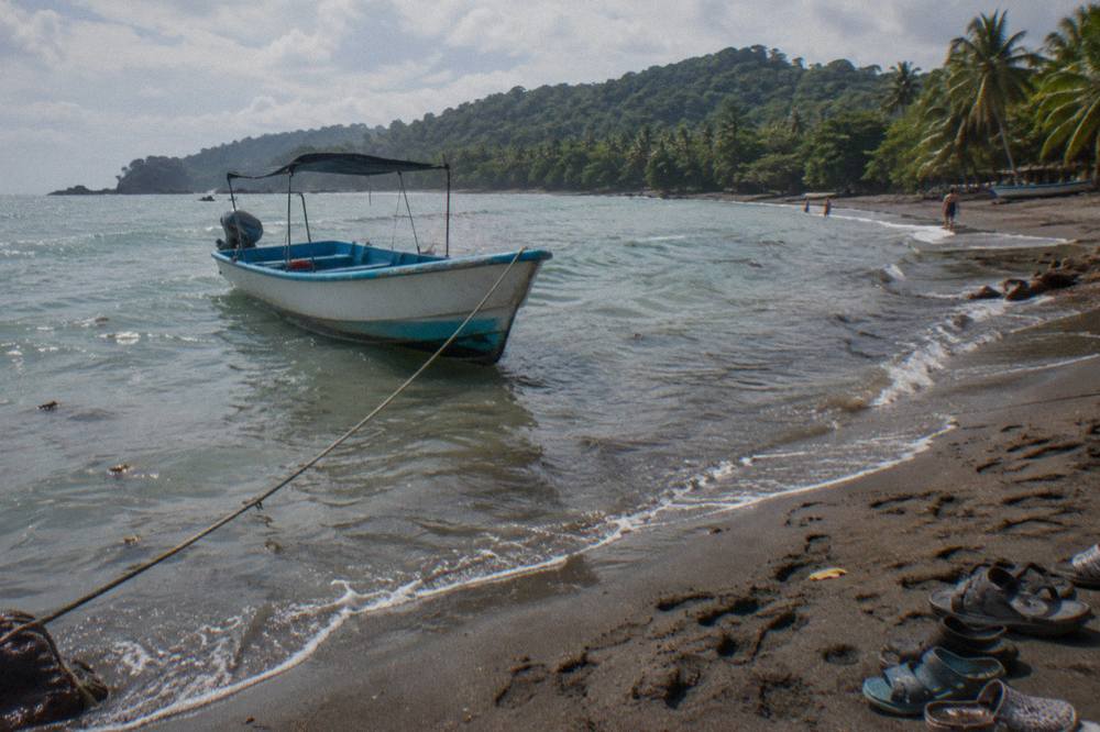 Boat anchored in shallow water near the Uvita beach departure point
