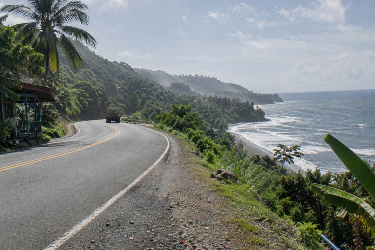 A coastal highway curving along green hills above the Pacific ocean