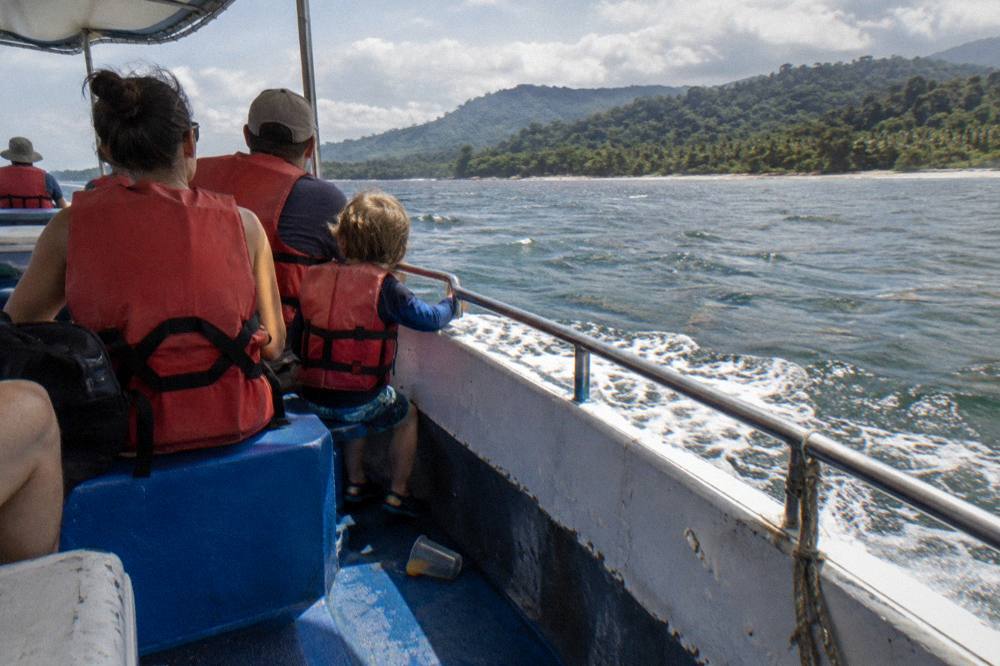 A family in life jackets sitting together on a tour boat deck