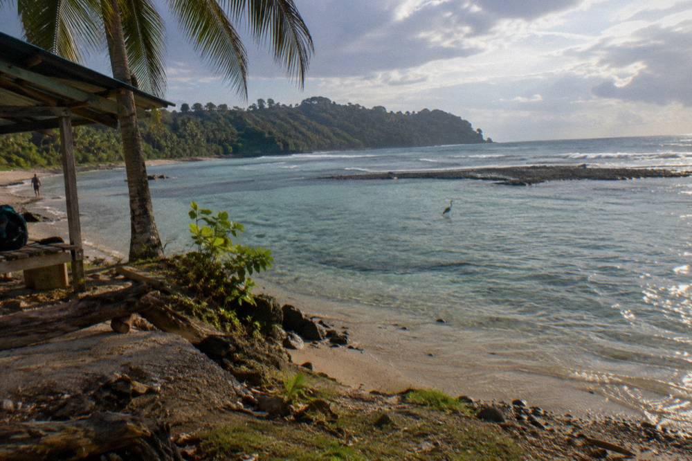 Calm turquoise water over a sandy shallows inside a protected bay
