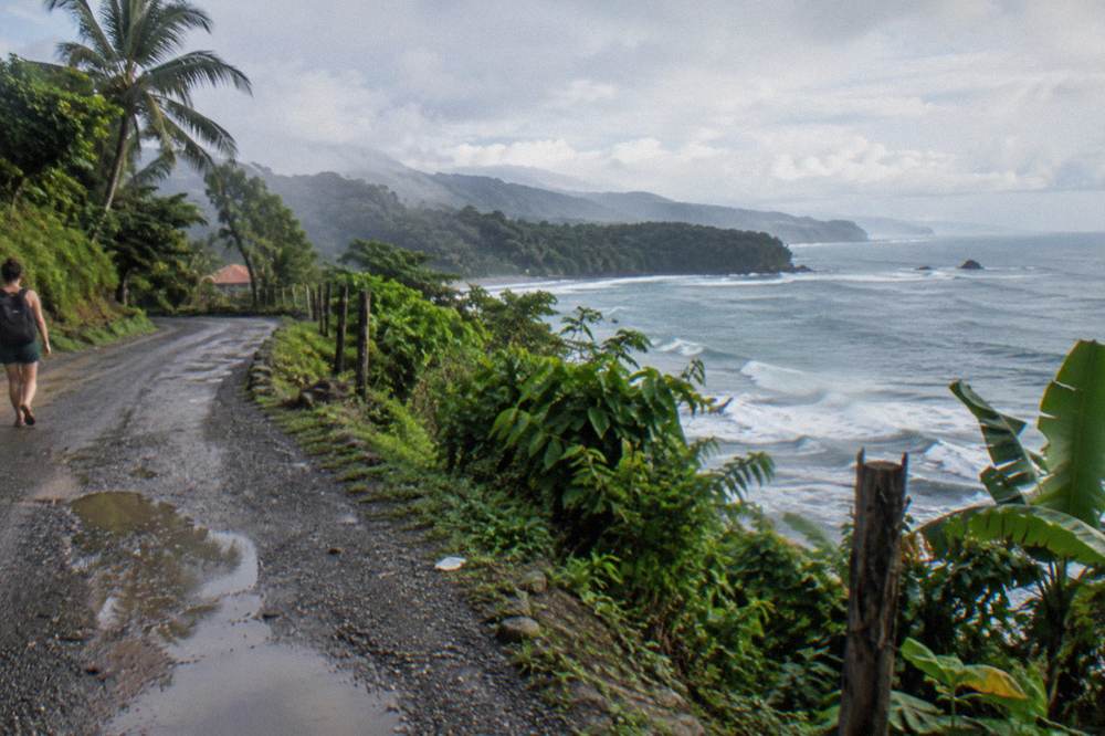 A coastal road winding along green cliffs above the Pacific ocean