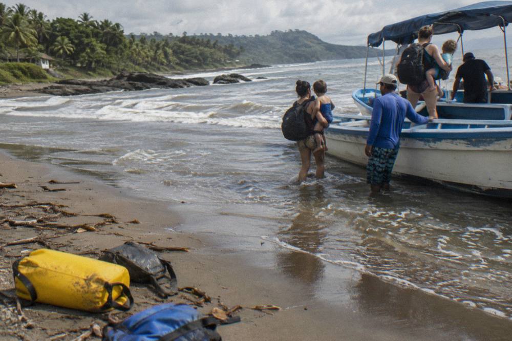A small tour boat loading passengers from the sand at low tide in Bahía Ballena