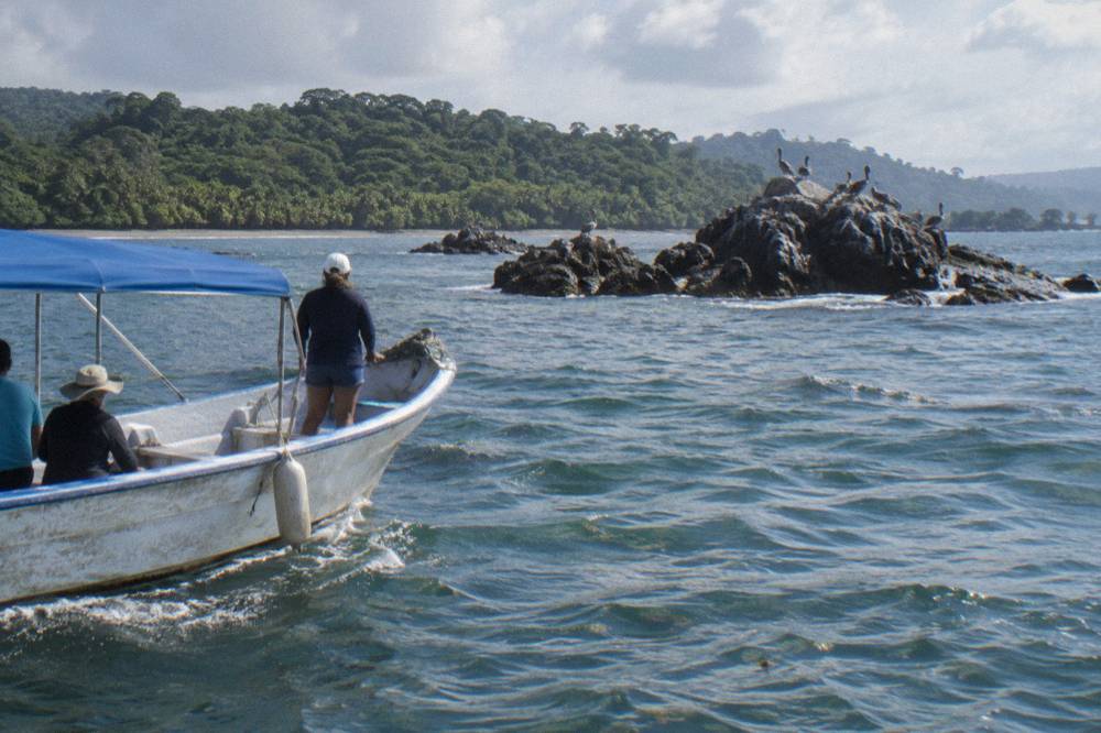A whale watching boat cruising past rocky islets inside Marino Ballena National Park