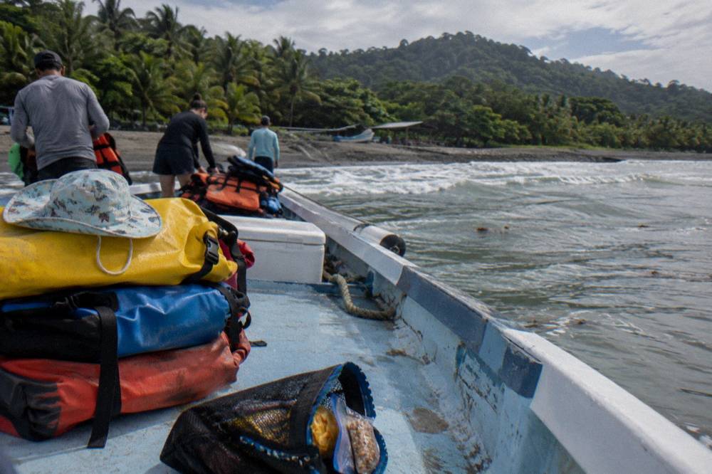 Beach gear and dry bags laid out on a boat deck before departure