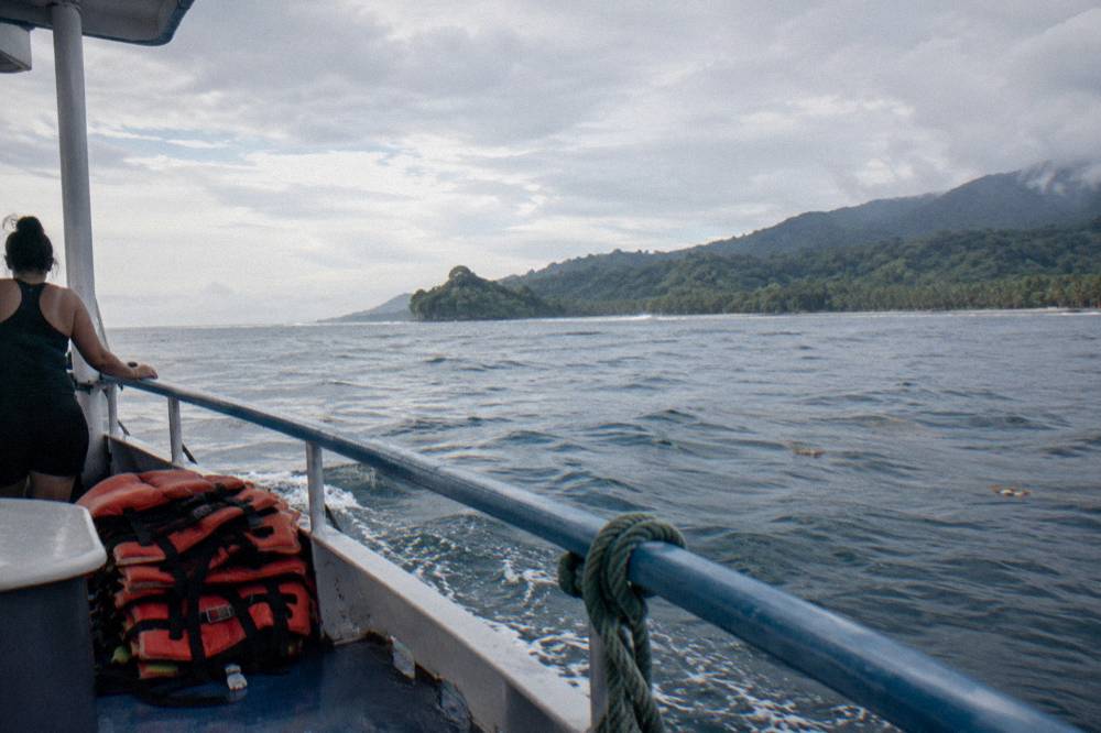 Calm morning sea horizon seen from mid ship on a small boat with a passenger looking outward