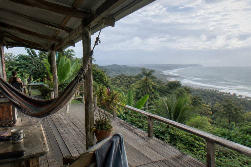 Wooden cabin with a wide veranda set in green jungle above the Uvita coastline